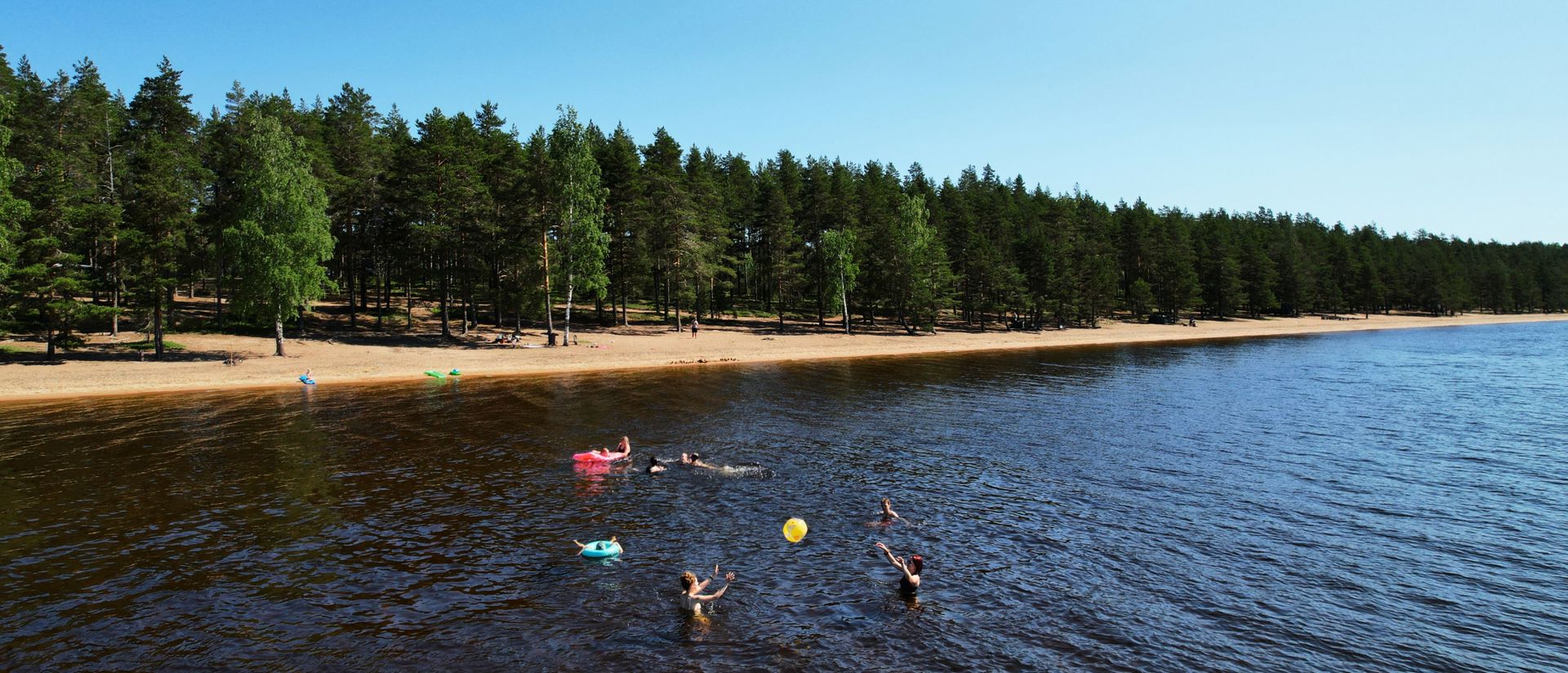 Ihmisiä pelaamassa rantavedessä Huuhanrannalla